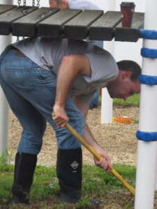 Henry Milliman of Avery Dennison tackles stubborn weeds growing under the swing set on the  playground at Forbes House on United Way’s Day of Caring.